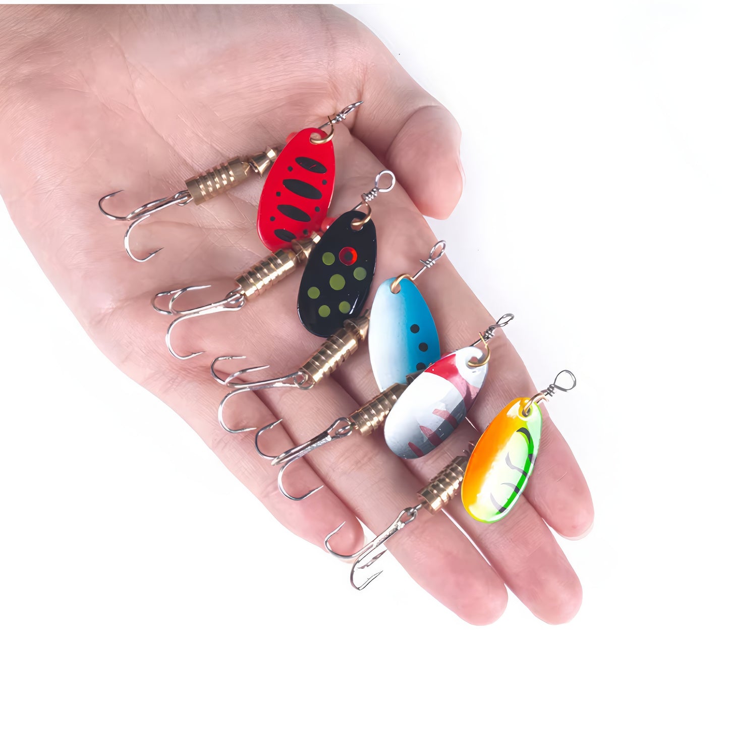 A hand holding five colorful in-line spinner fishing lures with various patterns including red, black with dots, and holographic finishes to show scale and variety.