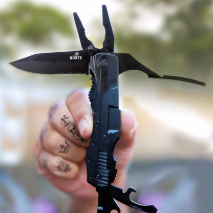 A hand holding a black Norte heavy-duty multitool with needle-nose pliers, partially serrated knife blade, and bottle opener extended against a blurred outdoor natural background.
